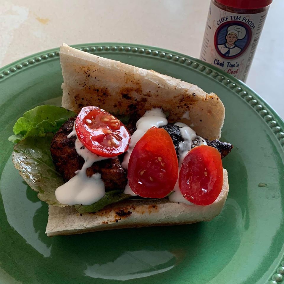 Blackened Chicken Sandwich with pita bread, tomatoes, and a sauce on a green plate with a bottle of Chef Tim's Cajun Cool Blackened Seasoning in the background.  A delightfully mild (4 out of 10) Cajun seasoning that tantalizes the senses but doesn't burn you. "Spicy but not hot."   

Made with both Hungarian sweet and Spanish smoked paprika. Naturally Gluten Free, Cholesterol Free & No MSG. 